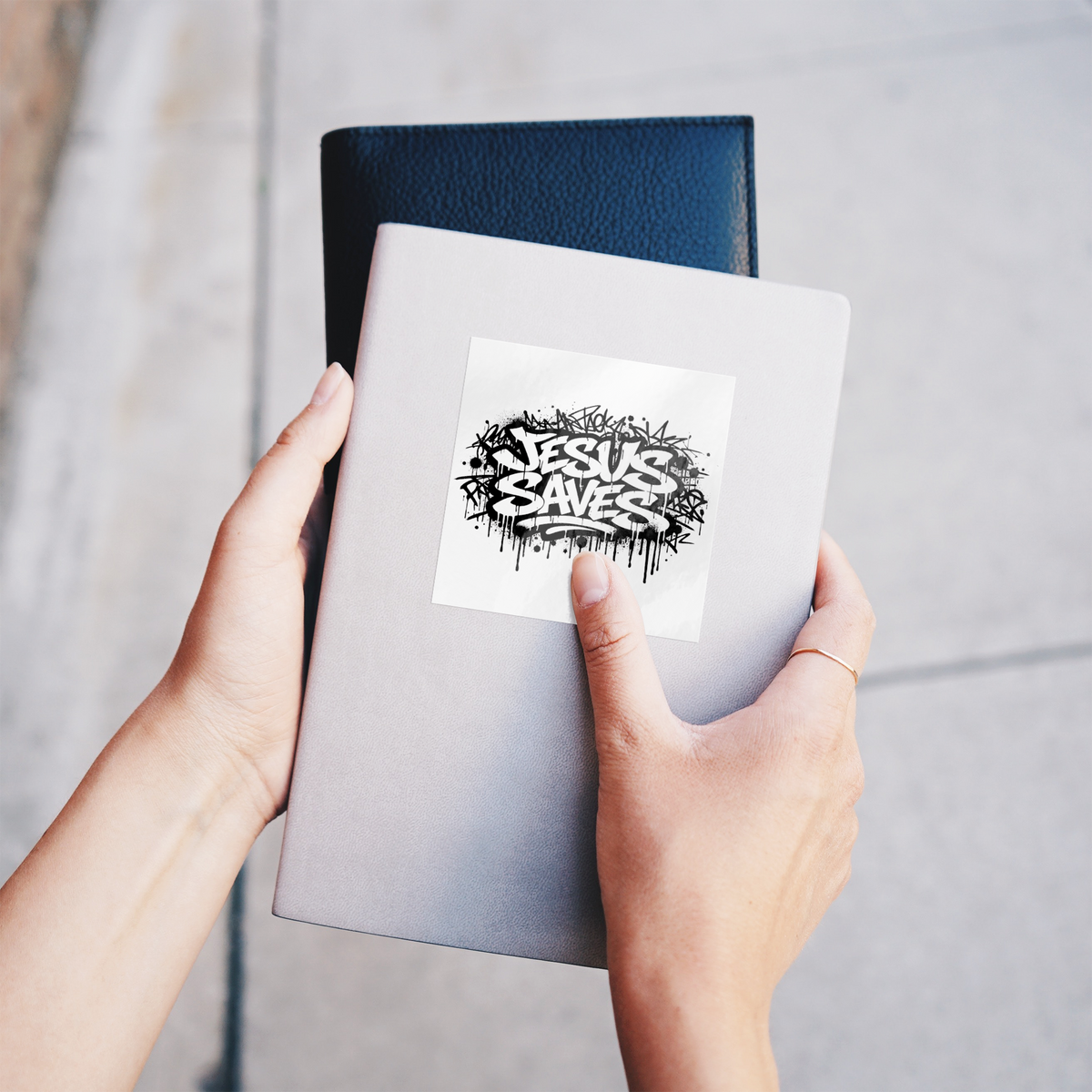Jesus_Saves_Sticker__Christian_Faith_St_WhiteSquareSticker_Notebook_Mockup.png_16190605